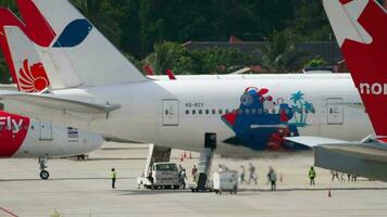 PHUKET, THAILAND NOVEMBER 28, 2019 - Boeing 777 of Azur Air on the airport apron. Boarding passengers on a flight. Airport staff aircraft maintenance video