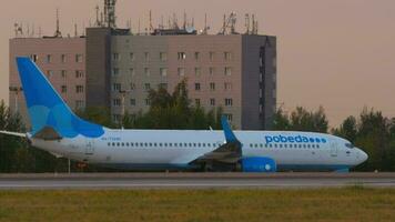 KAZAN, RUSSIA AUGUST 05, 2022 - Passenger plane Boeing 737 of Pobeda on taxiway, sunset or sunrise at Pulkovo airport. Tourism and travel concept video