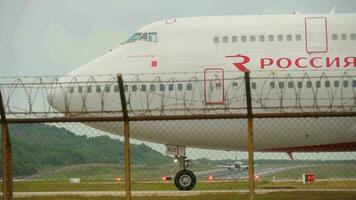 phuket, Tailandia noviembre 26, 2017 - pasajero chorro avión boeing 747 de rosiya rodaje en pista a phuket aeropuerto, cerca arriba. turismo y viaje concepto video
