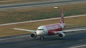 PHUKET, THAILAND FEBRUARY 23, 2023 - Middle shot of Airbus A320 of AirAsia plane taxiing at Phuket Airport, side view. Close flaps, braking. Airliner on the taxiway. Asian low cost airline video