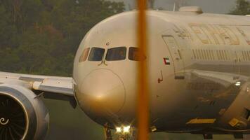 PHUKET, THAILAND FEBRUARY 20, 2023 - Passenger aircraft Boeing 787 9 Dreamliner, A6 BNC of Etihad Airways taxiing, front view through airport fence. Airfield. Tourism and travel concept video