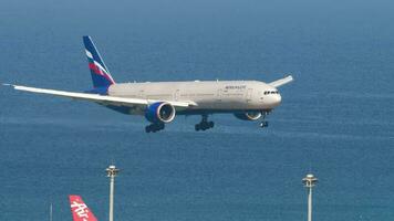 phuket, Tailandia febrero 20, 2023 - boeing 777 de aeroflot aterrizaje, conmovedor y frenado a phuket aeropuerto. aeronave llegando, lado vista. avión en el antecedentes de el Oceano video