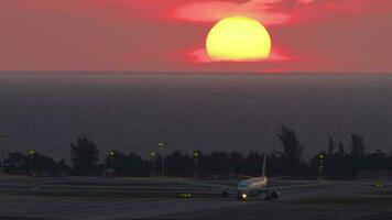 Cinematic footage of a jet aircraft on the airfield at sunset. Background big setting sun. Sunset over the airport video