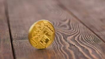 bitcoin coin spinning on wooden background - close-up with slow-mo video