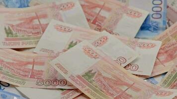 langzaam draaien achtergrond van Russisch roebel bankbiljetten verspreide Aan vlak oppervlakte video