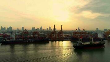 Antenne Aussicht 4k Video durch Drohne von Container Schiffe und Heben Kräne im das Hafen von Bangkok auf Sonnenaufgang.