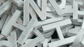full frame close-up looped slowly rotating background of silver metal letters with selective focus video