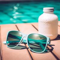 Summer holidays by the pool suntan lotion and sunglasses photo