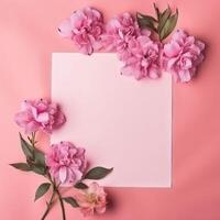 Pink flowers on a pink background with a white blank sheet photo