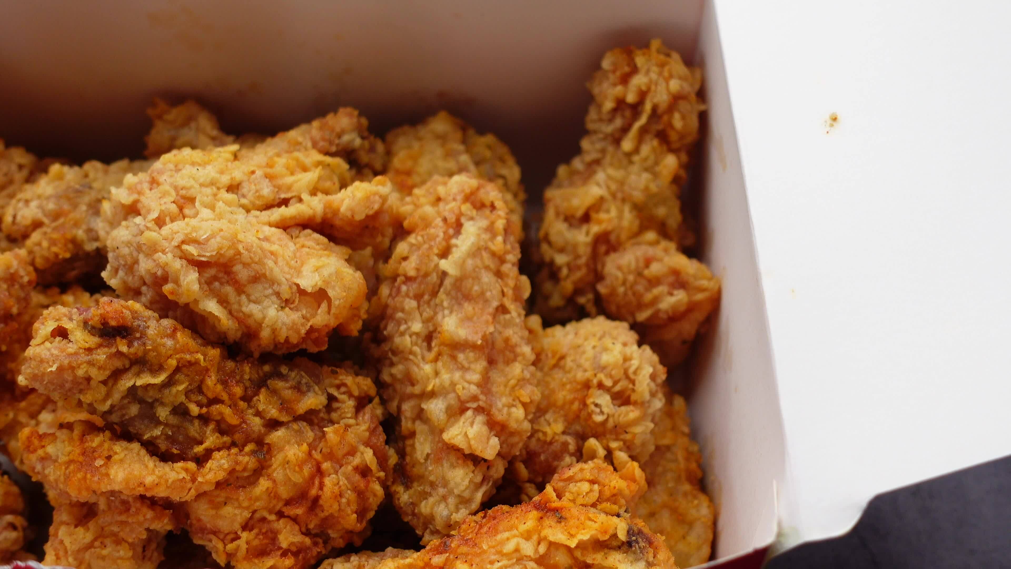 Crispy fried chicken wings on a take away paper packet on table 24487778 Stock Video at Vecteezy