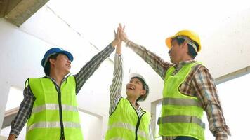 Engineer team and contractor raise their hands up together for joining hands in factory construction building after build success, Concept of success business of engineering partnership. video