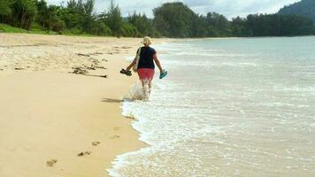 Barefoot woman walking on a beach with sandals in hand, Mai Khao Beach, Phuket video