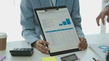 Financial analysts analyze business financial reports on a digital tablet planning investment project during a discussion at a meeting of corporate showing the results of their successful teamwork. video