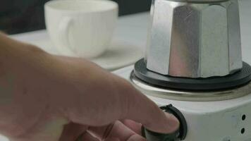 Mokapot on electric stove on white table close-up. Coffee maker video