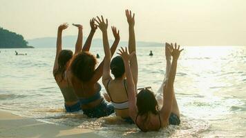 un grupo de adolescentes corren y juegan en la playa durante sus vacaciones de verano y sonríen y disfrutan de sus vacaciones. foto