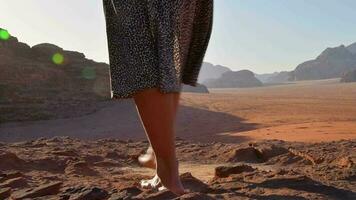 Close up oman barefoot walk on rocky Wadi rum cliffs surface on sunrise. Sunburst intentional filter blur video