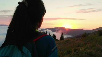 Circular back view hiker backpacker portrait on forest trail enjoy dramatic sunset over clouds in remote caucasus mountains warm summer evening video