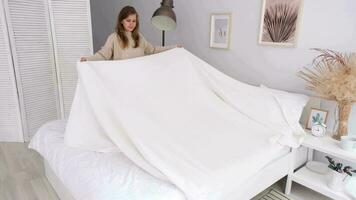 caucasien femme fabrication sa lit dans le Matin. Jeune millénaire femme Faire sa Matin routine à le chambre video