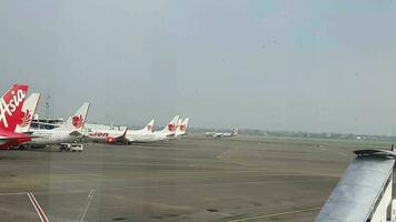 Tangerang, Indonesia in May 2023. Several aircraft, namely Air Asia, Lion Air and several other aircraft on the apron and runway of Terminal 2 of Soekarno Hatta Airport. video