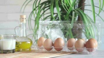 eggs in a plastic case, milk, oil and nut on table video