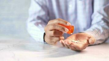 La main de l'homme avec un médicament renversé du contenant de la pilule video