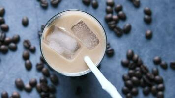 Ice coffee in a tall glass on black background video