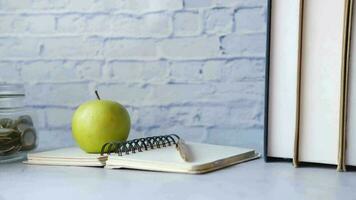 Back to school concept with apple on notepad on table video