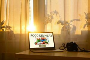 Food take away website in a laptop screen. Lunch at the office. photo