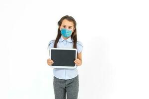 Masked child - protection against influenza virus. Little Caucasian girl wearing mask for protect pm2.5. baby on a gray background with copy space. epidemic, pandemic. photo