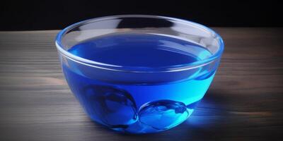 Small glass bowl with blue liquid in it photo