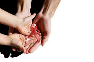 red aids ribbon in hand. photo