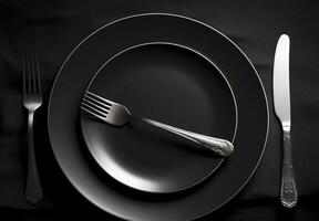 Empty plate with fork and knife on black. Served cutlery, minimal dark table setting. Menu mockup, space for text, diet concept. photo