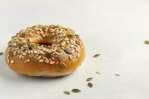 Tasty bagel with sesame and pumpkin seeds on light background, generate ai photo