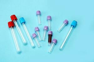 a test tube filled with blood among many empty test tubes on a blue background photo