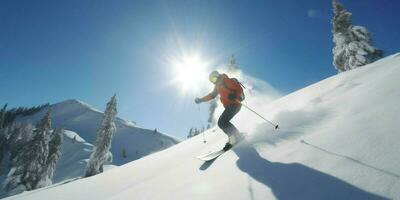 A skier is going down on a snowy mountain photo