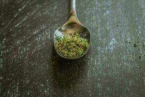 Spoons with spices and herbs on a black background. Food and cuisine ingredients. photo