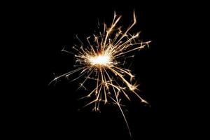 Burning sparkler isolated on black background. Fireworks theme. Light effect and texture. photo