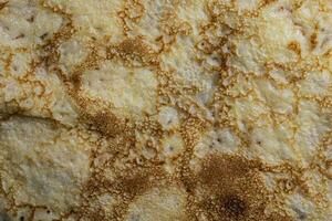 Pancake surface texture and pattern. Close-up of thin hot pancakes in a plate. Traditional rustic food. Graphic resource. photo