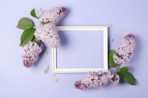 Lilac flowers sprigs and a white rectangular frame with copy space on light purple background, top view. . photo