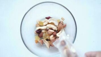 close up of many mixed nuts pouring in a bowl video