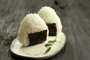 triángulo onigiri, japonés arroz lleno pelota con nori foto