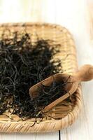 Dried Hijiki Seaweed on Ceramic Bowl  and Wooden Spoon. photo