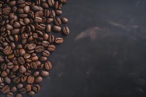 Roasted coffee beans on black background, top view with copy space. . photo