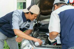 dos auto reparador cheques el motor y enfriamiento sistema antes de de viaje en un largo día festivo. concepto de coche cuidado y mantenimiento desde expertos, entrenamiento, y Consejo para practicando un coche desde un experto foto