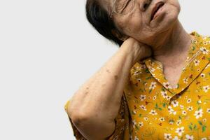 Sick senior woman with back neck and shoulders pain on the joint and muscle. Close-up of wrinkled hands rubbing their neck-collar area, osteoarthritis, neurological diseases. Medicine concept photo