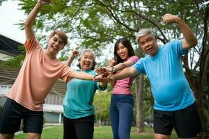 Healthy family group instructors workout in fresh air, and they rest and stand together after morning exercises in park. Outdoor activities, healthy lifestyle, strong bodies, fit figures, health care. photo