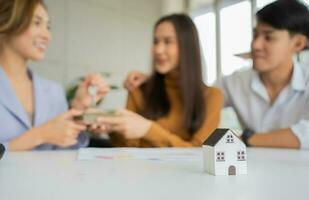 el agente inmobiliario entrega la llave al cliente después de firmar el documento del préstamo hipotecario con el agente inmobiliario o el abogado. concepto de seguro o préstamo inmobiliario, comprar una casa. foto