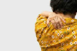 Sick senior woman with back neck and shoulders pain on the joint and muscle. Close-up of wrinkled hands rubbing their neck-collar area, osteoarthritis, neurological diseases. Medicine concept photo