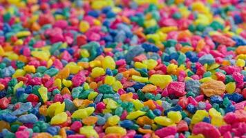 crushed colored stones on flat surface, slowly spinning, loopable closeup video