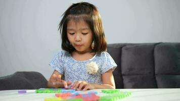 süß asiatisch wenig Mädchen spielen mit bunt Spielzeug ABC Puzzle, Kinder abspielen mit lehrreich Spielzeuge beim Kindergarten oder Kindertagesstätte. kreativ spielen von Kind Entwicklung Konzept, Kleinkind Kind im Kindergarten. video